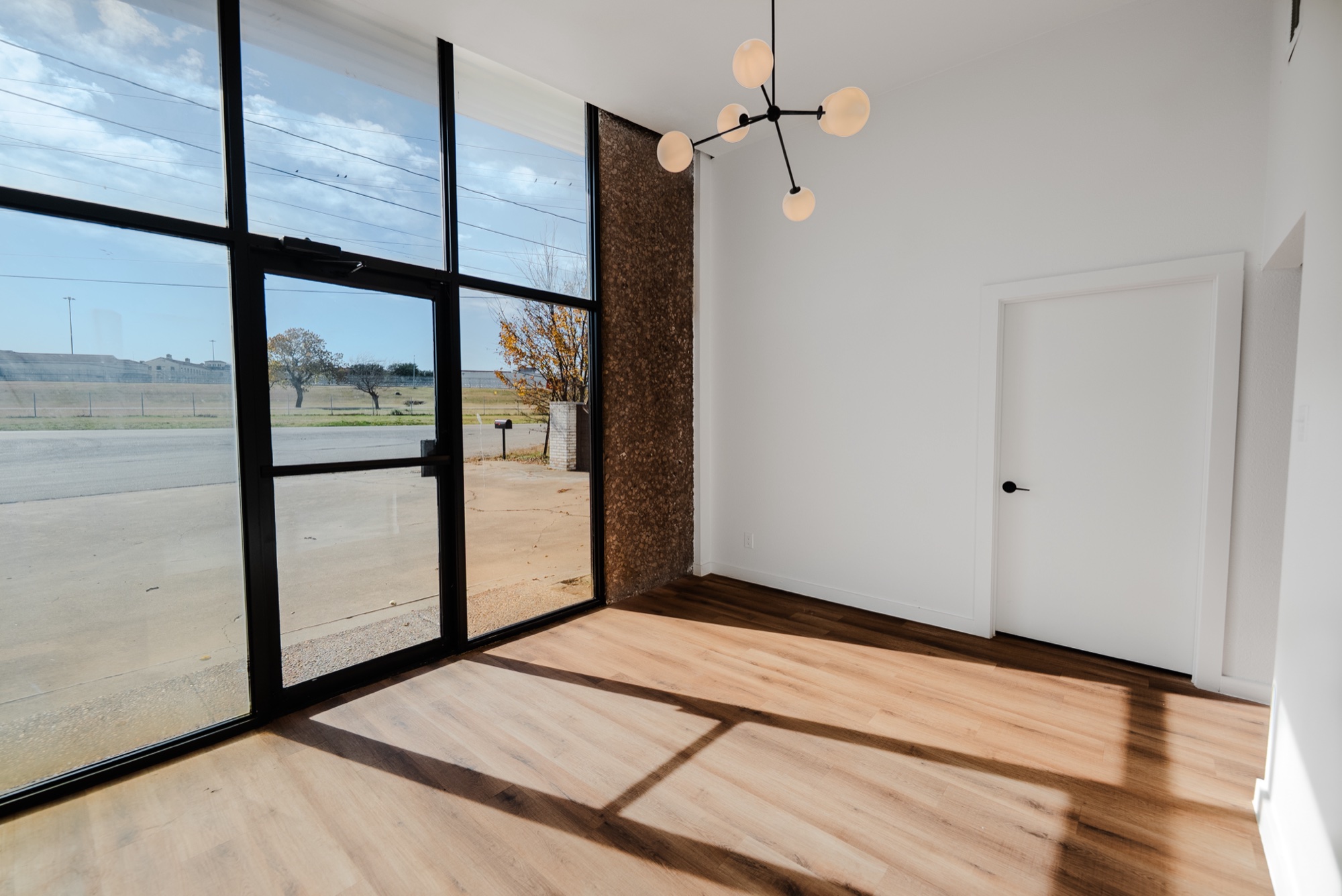 Renovated lobby with sputnik chandelier and floor-to-ceiling glass at 3115 Sabine St